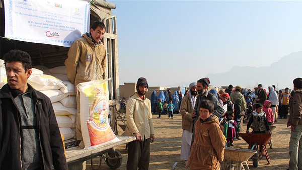 カブールの国内避難民キャンプで食糧などの配布物資を待つ人の列。©NFUAJ