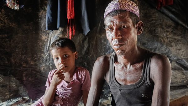 カメラを見つめる父と子©Turjoy Chowdhury/Disasters Emergency Committee