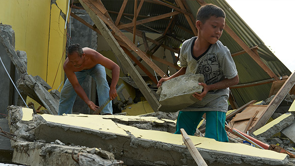 被災した自分達の家の瓦礫を撤去する家族／10月7日／シギ県、インドネシア ©Lewis Inman/Arete Stories/DEC