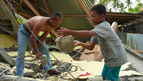 被災した自分達の家の瓦礫を撤去する家族／10月7日／シギ県、インドネシア ©Lewis Inman/Arete Stories/DEC
