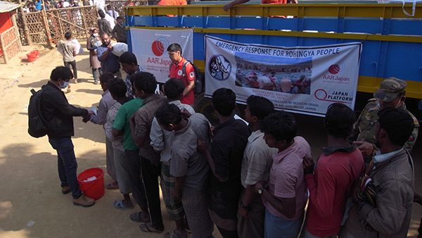 Refugees queuing for the distribution of relief items at the distribution point in Kutuparon refugee camp. The one in the middle with red t-shirt is Fukuro Kakizawa from AAR Japan/ January, 2018/ Kutuparon Refugee Camp ©AAR