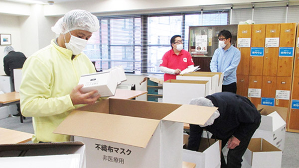 Sheltered workshop workers carefully checking boxed masks and packing them into cardboard boxes ©AAR