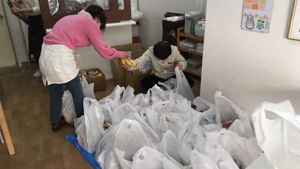Volunteers help prepare food packages ©PARCIC