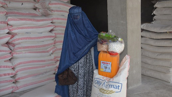 食糧を受け取る女性裨益（ひえき）者（アフガニスタン）©CWSA