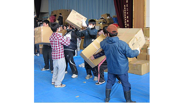 Photo [©PWJ]: Bringing relief items into the gymnasium serving as an evacuation shelter